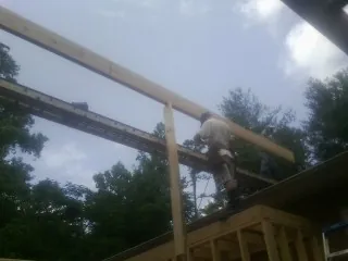 Carpenter setting a ridge beam over a new addition frame — Ice Dam Removal by Roofing Brothers in Fountain Green