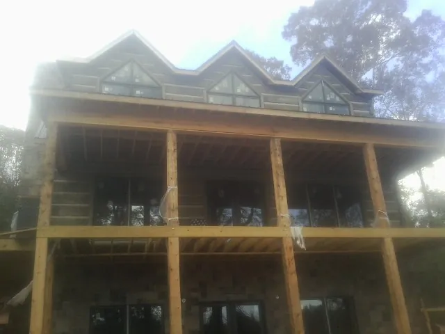 Dormers and porch framing on a large log home under construction — Roof Coating work by our crew in Fountain Green
