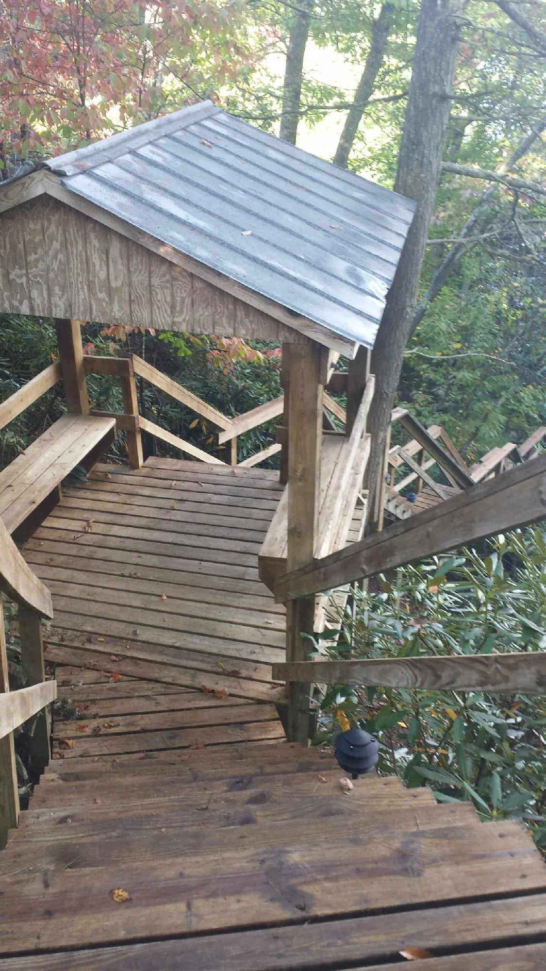 Metal roofed shelter over wooden steps on a wooded walkway — Skylight Repair & Installation work by our crew in Fountain Green