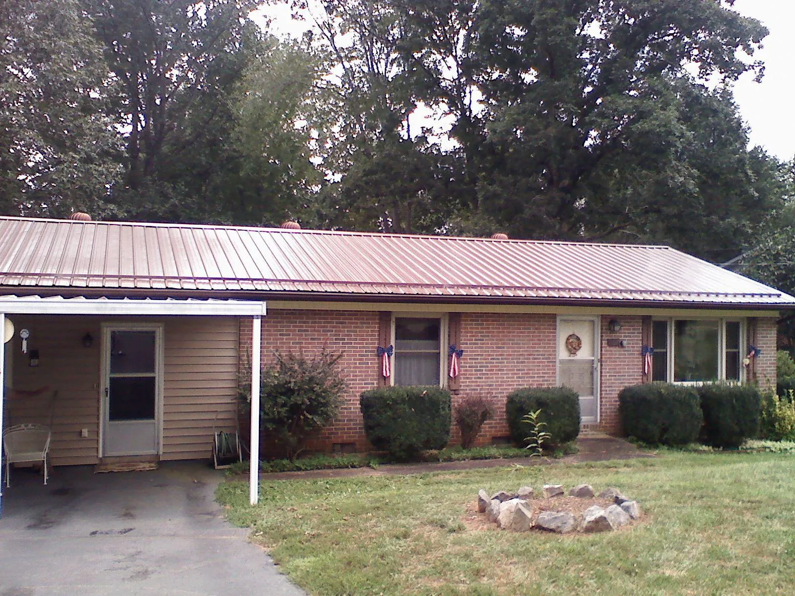 Bronze metal roof and carport on a brick ranch home — Roof Repair work by our crew in Fountain Green